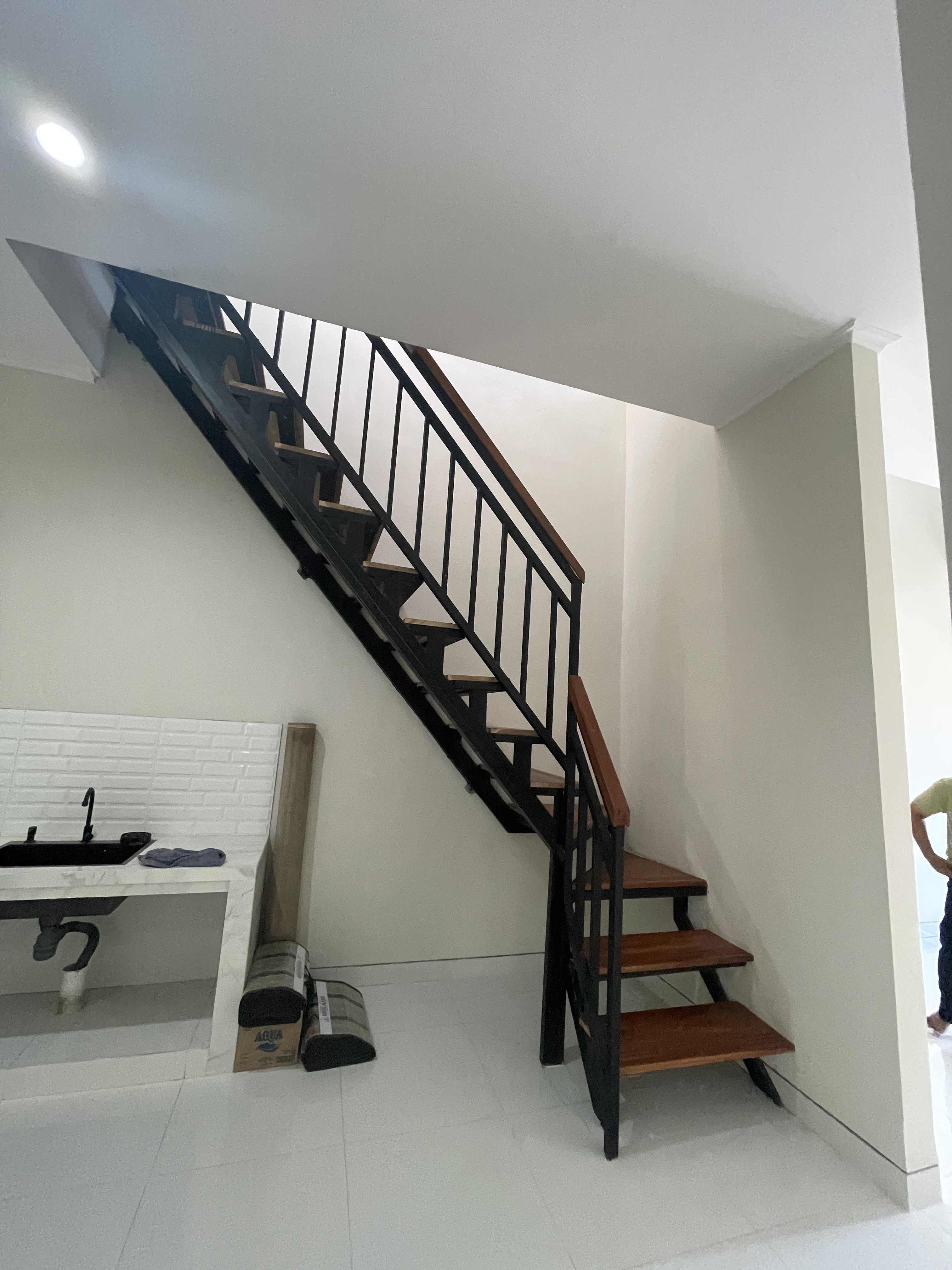 Rumah minimalis dengan tangga menuju lantai 2 yang berada di dapur